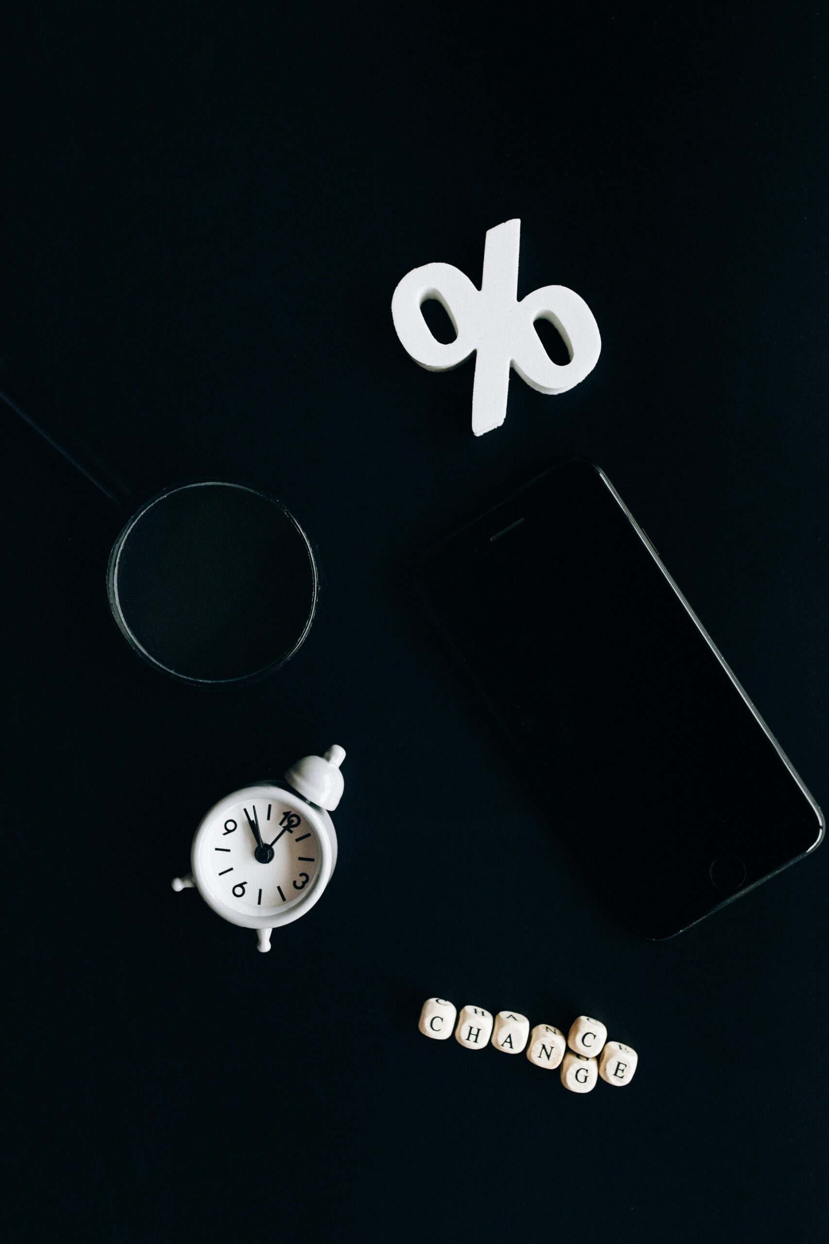 Stylish composition of clock, symbols, and text representing financial change on a dark background.